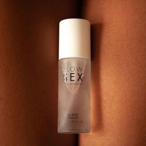 Tanned Legs holding the Bijoux Indiscrets Slow Sex Full Body Massage Gel 1.69oz bottle between thighs