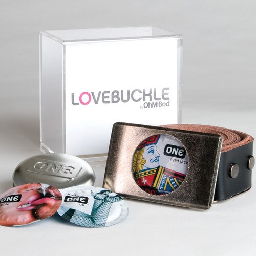 An image of the lovebuckle belt curled to the right, its box behind it, and several One condoms to the left.