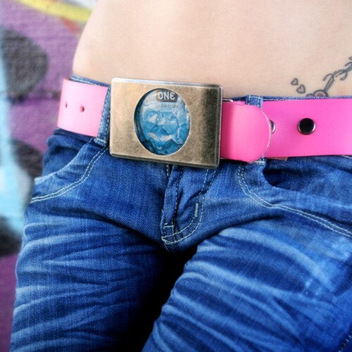 An image of a woman's hips wearing blue jeans held up by the stylish pink lovebuckle belt.