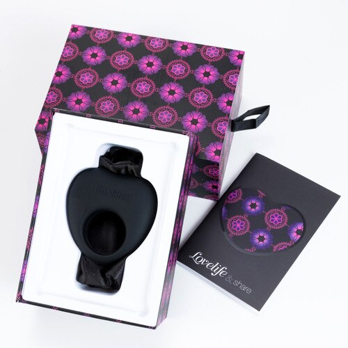An image of the open packaging of the Share, showing the massager in its box with the box lid behind it and the product manual to the side.