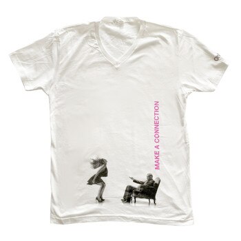 An image of a white v-neck t-shirt with the ohmibod logo on the left sleeve and a black and white image of a man and woman using the Nex 1 across the belly, with "make a connection" in pink