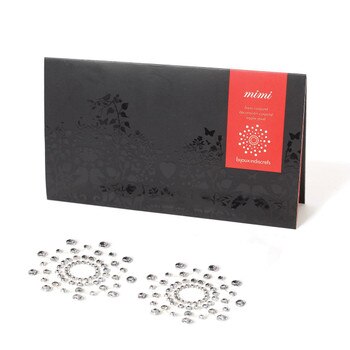 An image of a pair of clear crystal rhinestone pasties arranged in a starburst shape next to their black and red packaging.